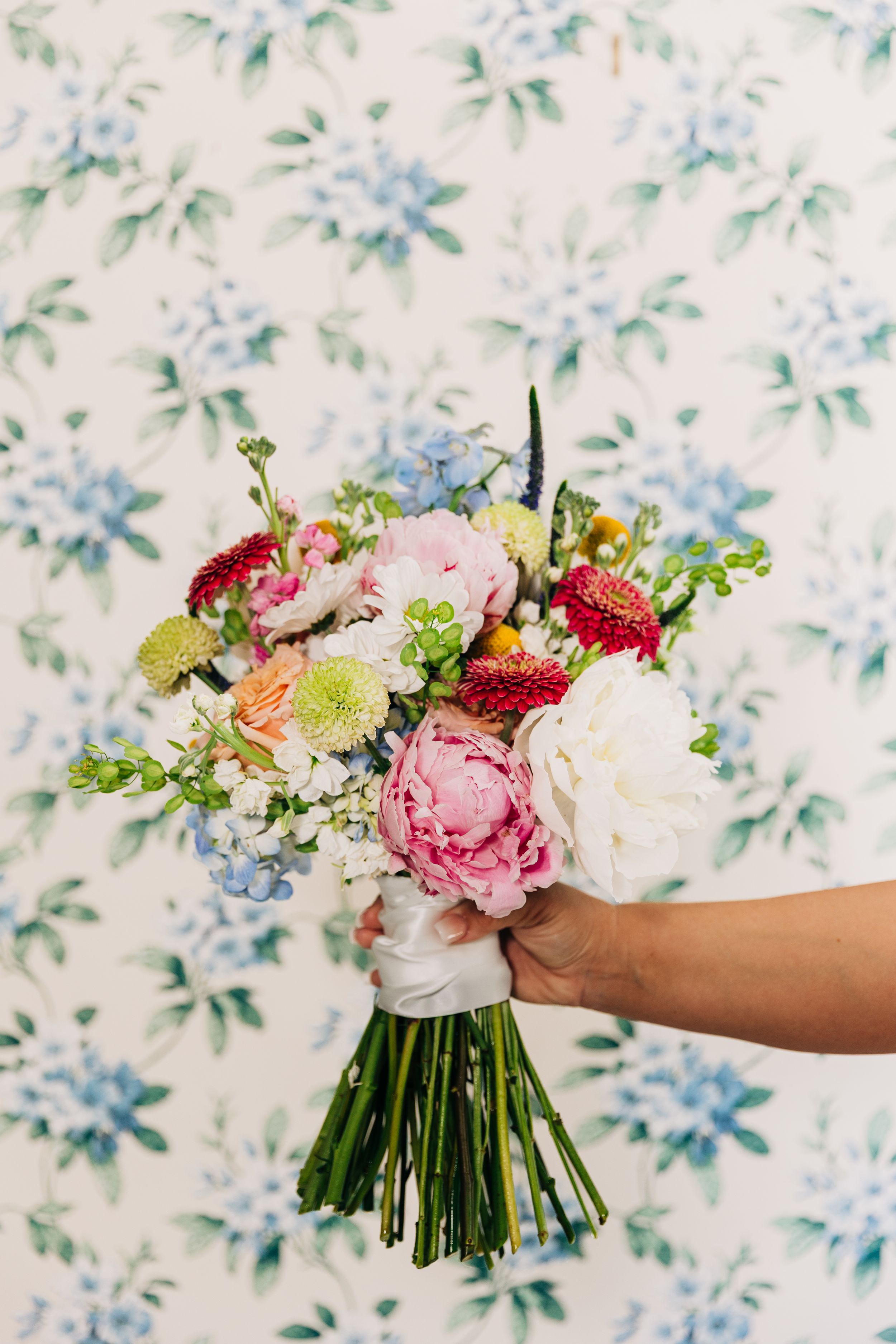 floral wallpaper at The Wildflower 301 with bouquet of pink, red, and white flowers in the foreground