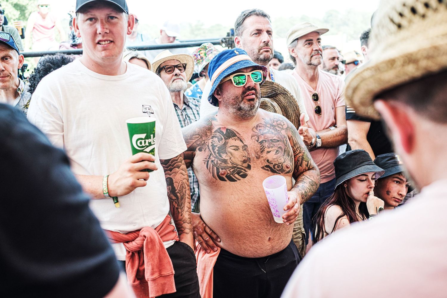Energetic crowd gathering at an outdoor music festival with audience members enjoying a lively atmosphere.