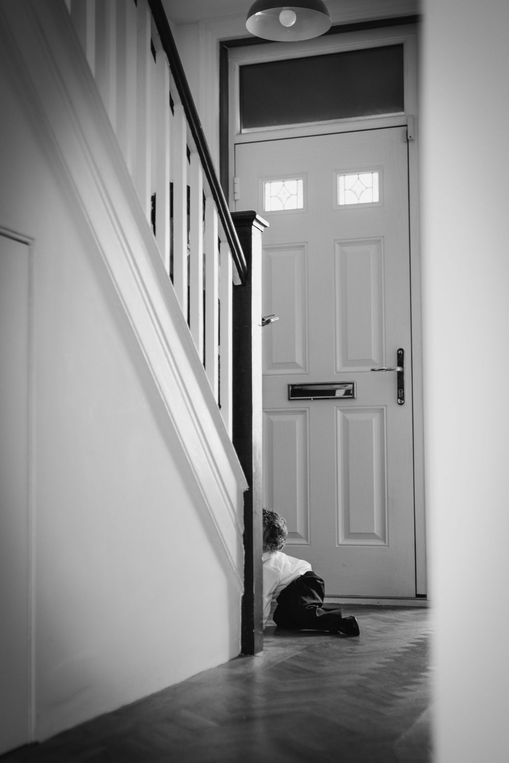 A series of minimalist black and white photographs showing an empty hallway with white walls and door.