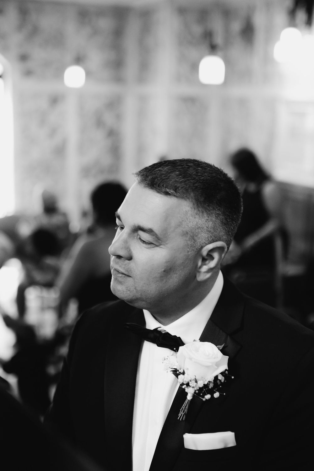 A close-up sequence of a groom in a tuxedo and bowtie at a formal event.