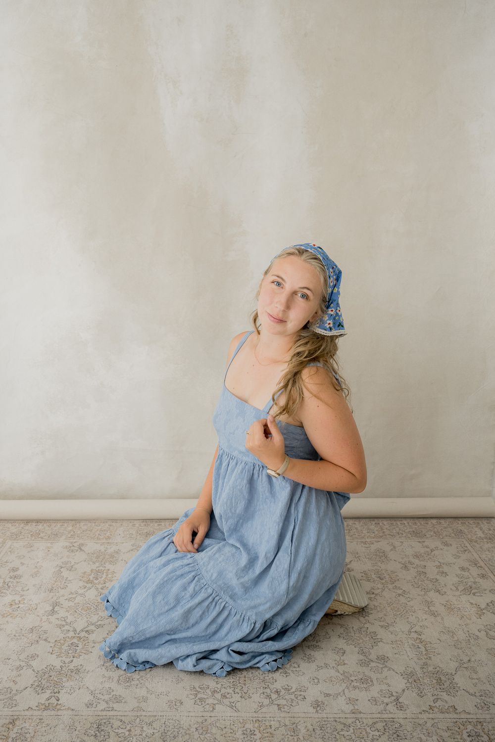 Artistic photo series showing someone in a flowing light blue dress posing gracefully on a neutral gray floor.