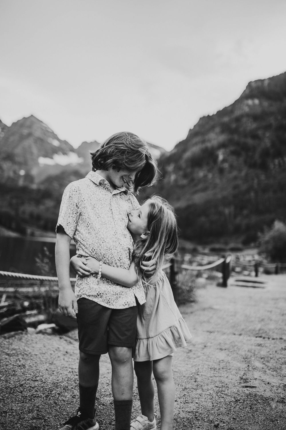 A heartwarming black and white sequence of two people sharing tender moments in front of mountain landscapes.