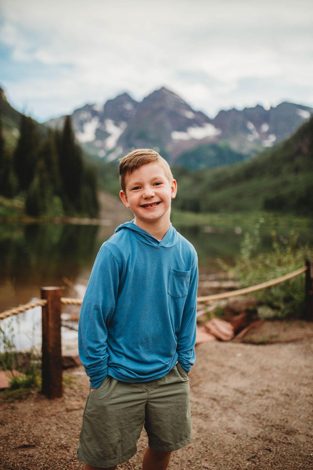 Candid outdoor portrait with majestic mountain peaks and a lake creating a scenic Colorado wilderness backdrop.