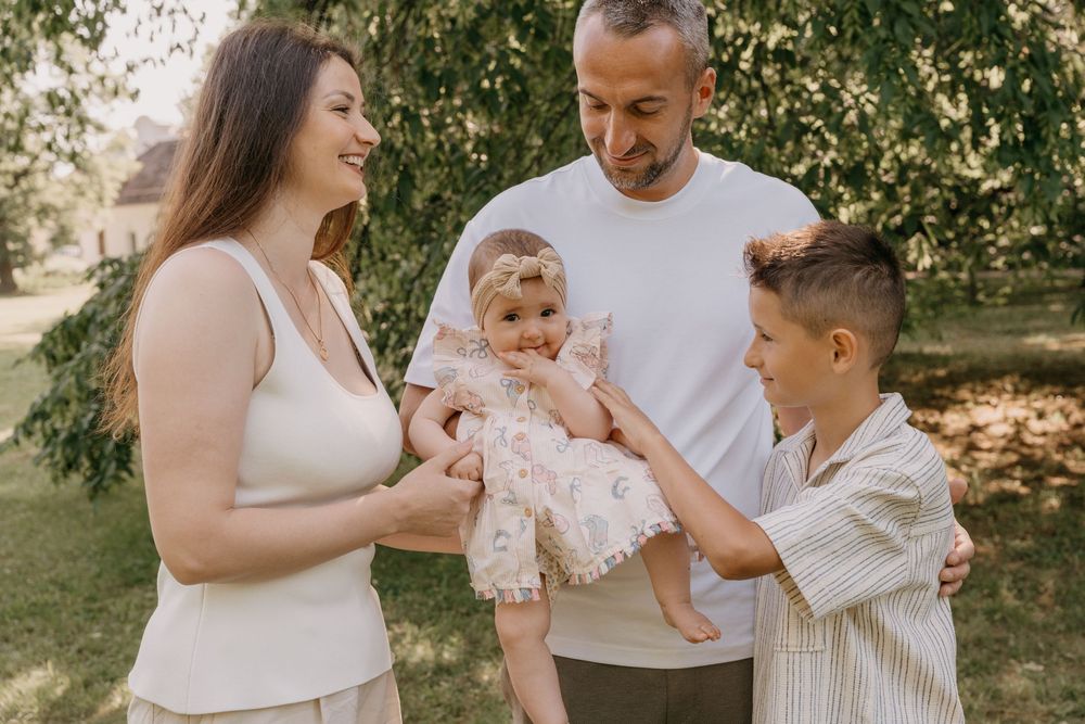 Eine Familie verbringt an einem sonnigen Tag gemeinsam einen freudigen Moment im Freien.