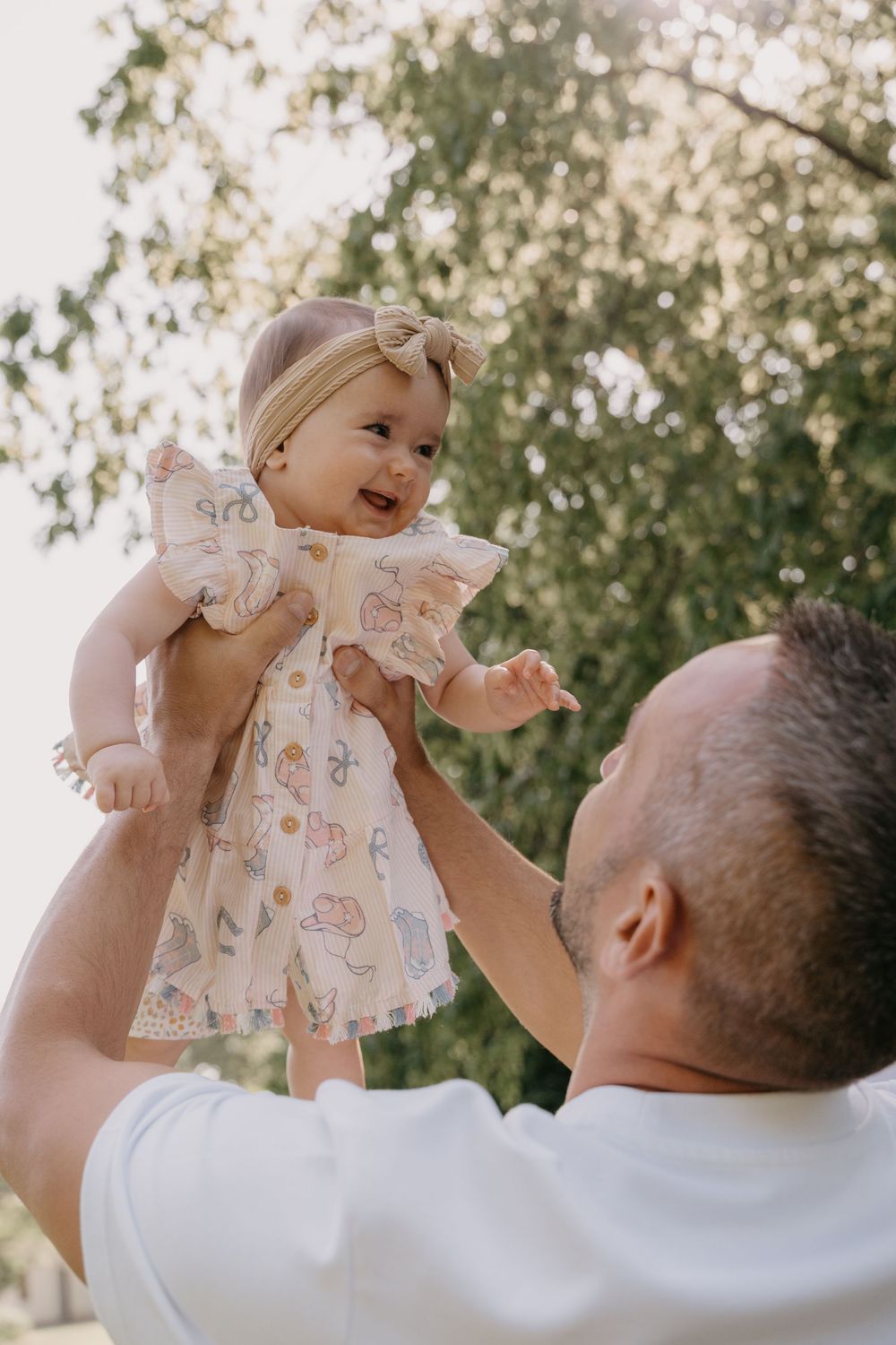 Papa lässt Baby hoch in die Luft fliegen. Ein freudiger Moment für Papa und Kind eingefangen für die Ewigkeit.