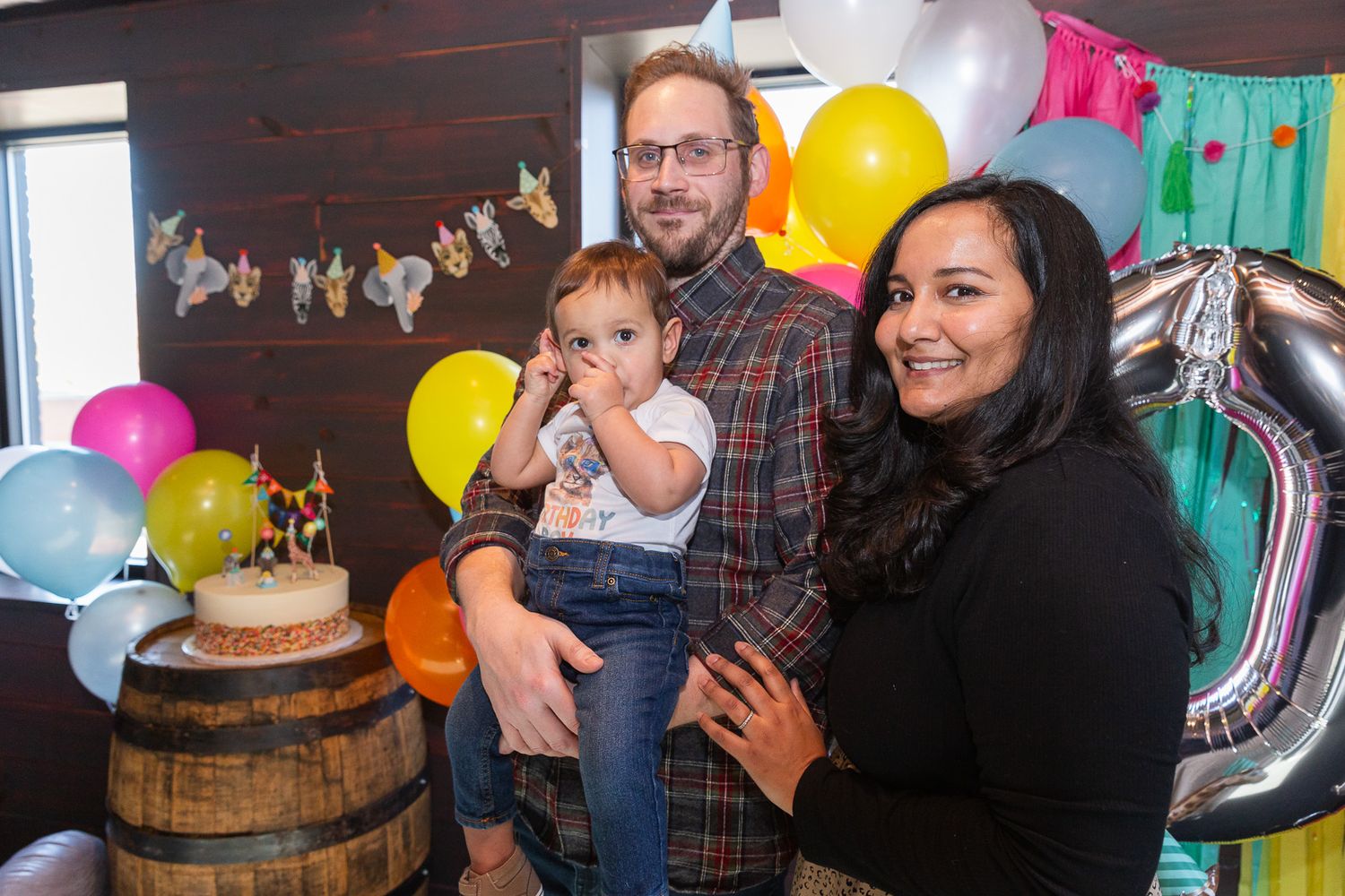 Birthday party scene with balloons and rustic barrel decor.