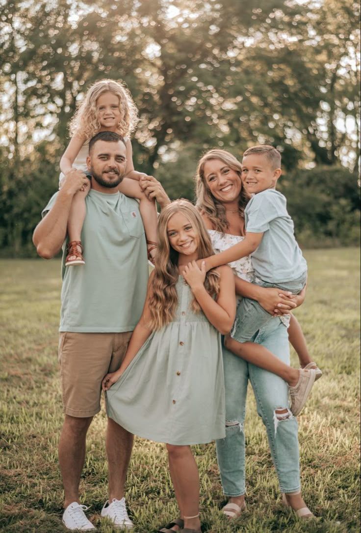 Coordinated spring family portraits in soft neutral tones with matching outfits outdoors at sunset.