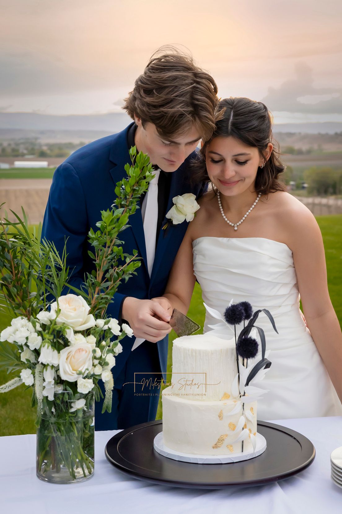 Bride and groom cutting cake-Cakes by Blythe, creamy white cake with black and white florals and gold details