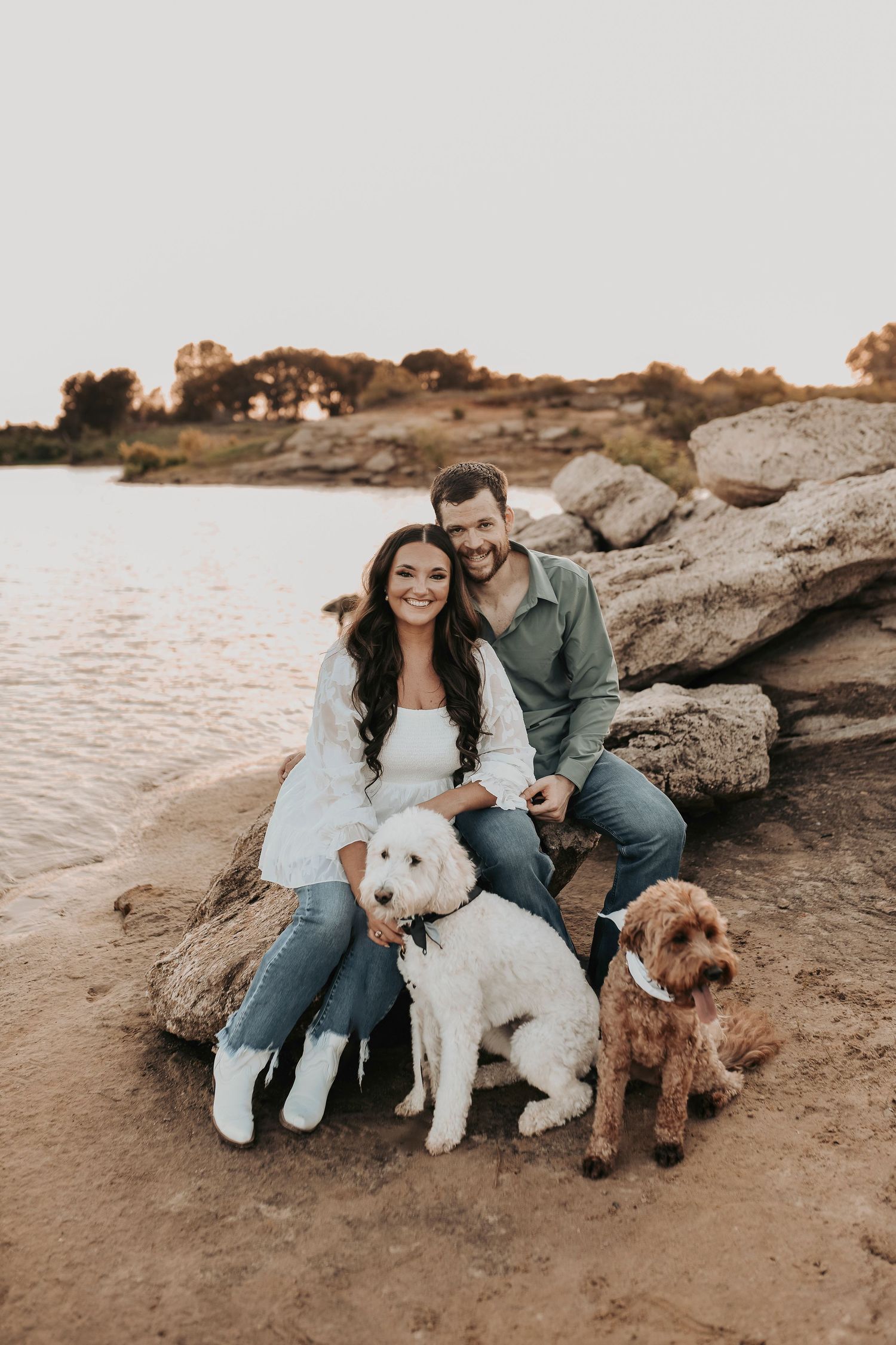 a sweet and newly engaged couple cuddles with their fur babies