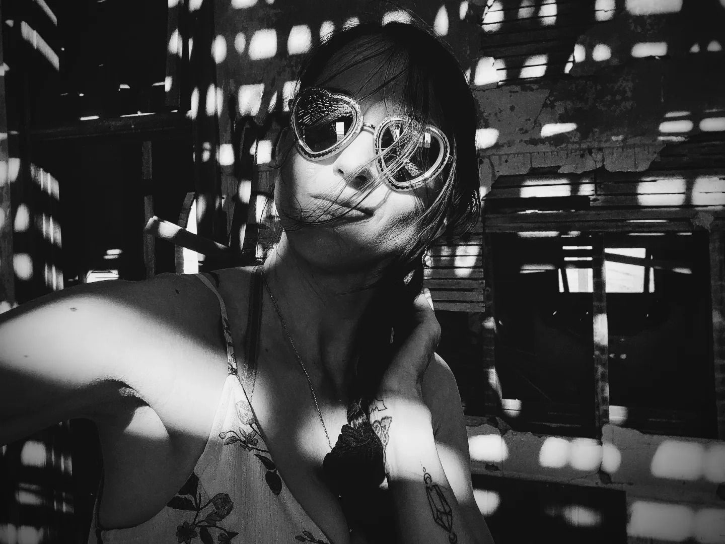 Artistic black and white portrait with dramatic lighting and geometric shadows.