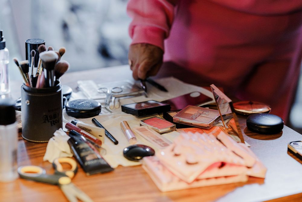 Wedding planning supplies and tools arranged on a wooden desk with brushes and accessories.