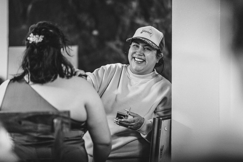 Wedding guests enjoying candid moments of laughter and celebration at a reception.