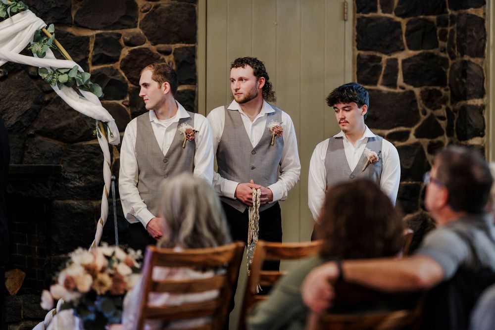 Stone-walled wedding venue decorated with white draping and elegant lighting for a ceremony.