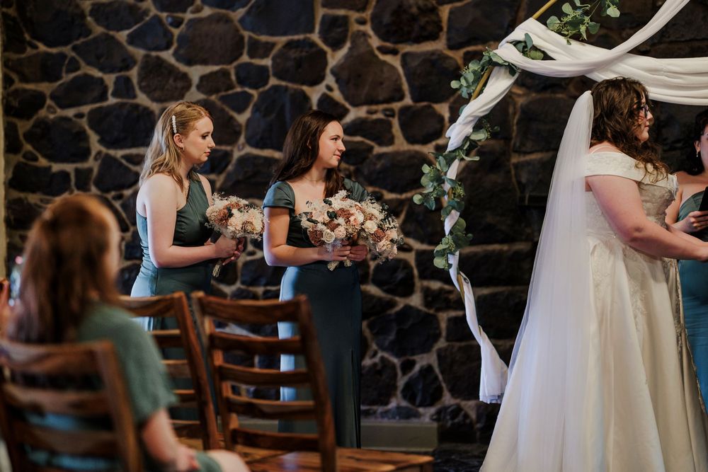 Wedding celebration at a rustic stone venue with guests gathering and socializing.