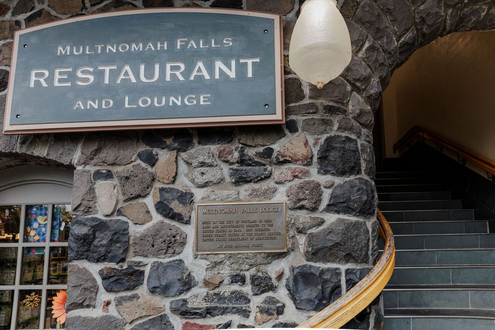 Stone facade of Multnomah Falls Restaurant and Lounge with signage mounted on exterior wall.