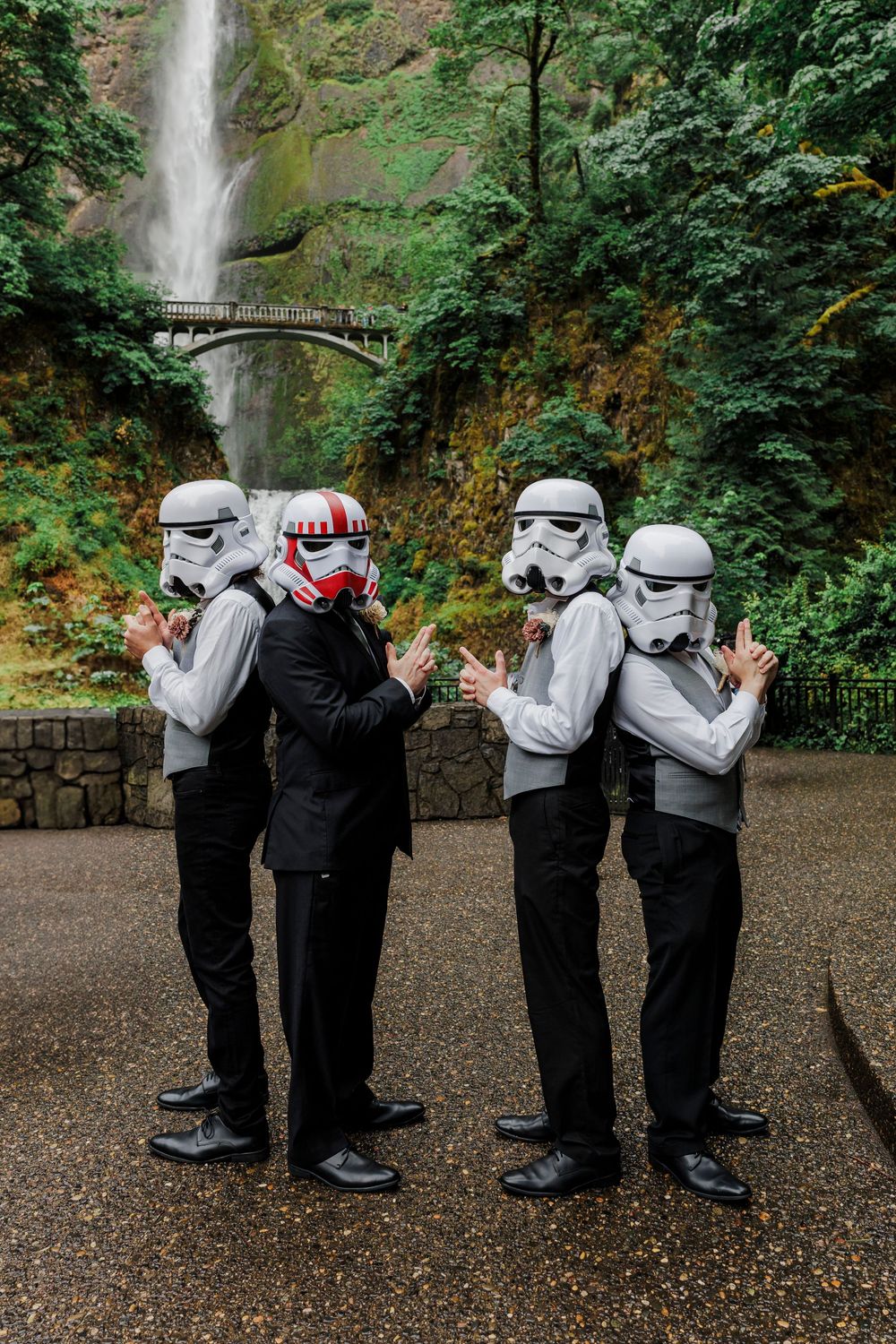 Groomsmen in Star Wars Stormtrooper helmets pose playfully at Multnomah Falls.