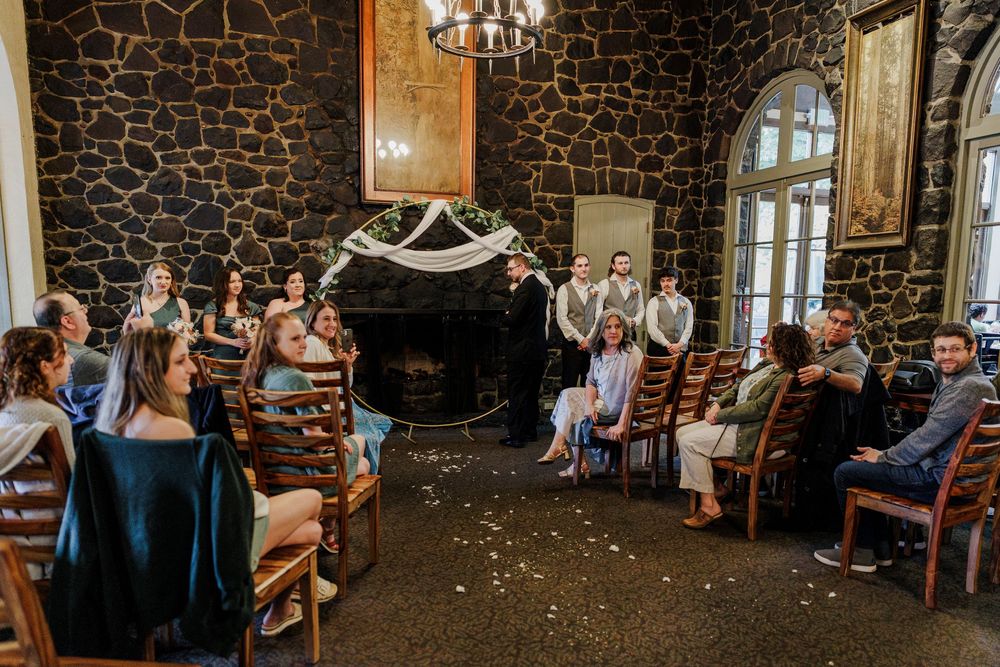 Stone-walled wedding reception venue with chandeliers and rustic decor.