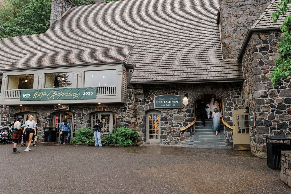 A rustic stone building entrance with stairs and archways leading to a visitor attraction entrance.