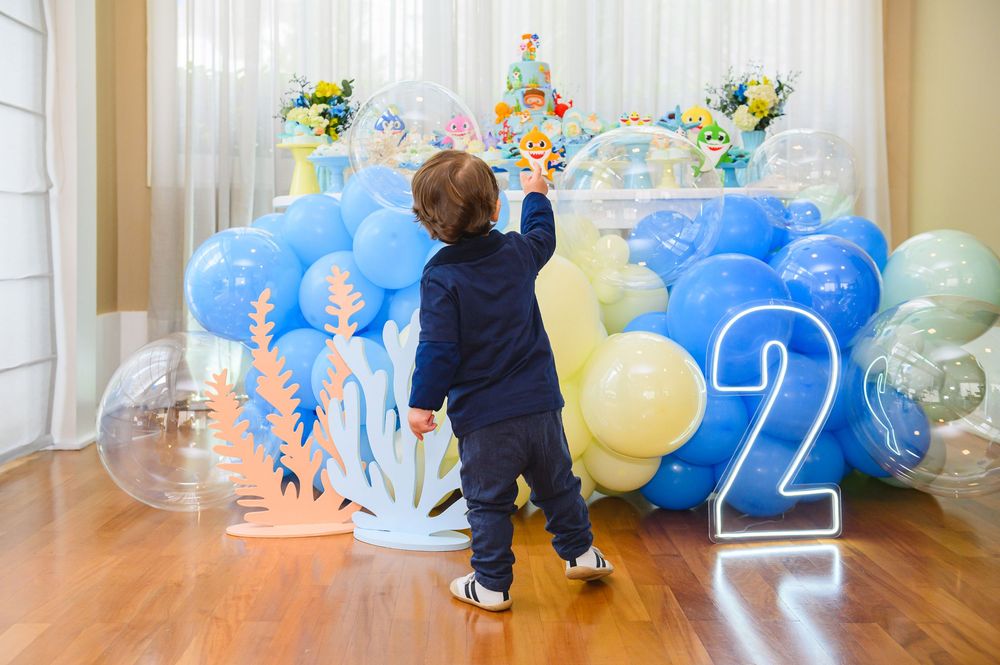 Festive blue and yellow balloon arch decorations set up in a sunny indoor room for a celebration party.