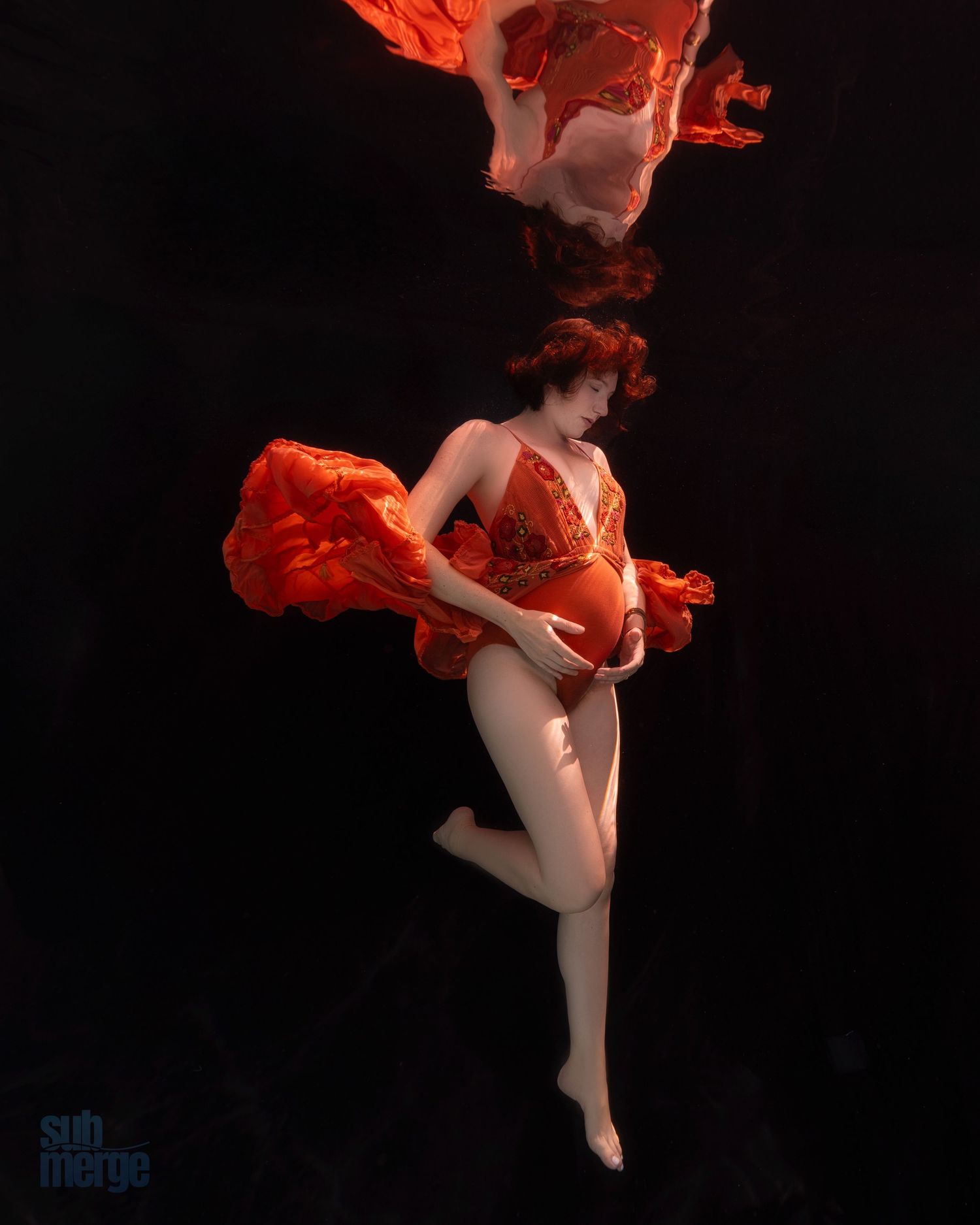 A levitating figure in a flowing red dress and dark background creates a dramatic floating effect against black space.