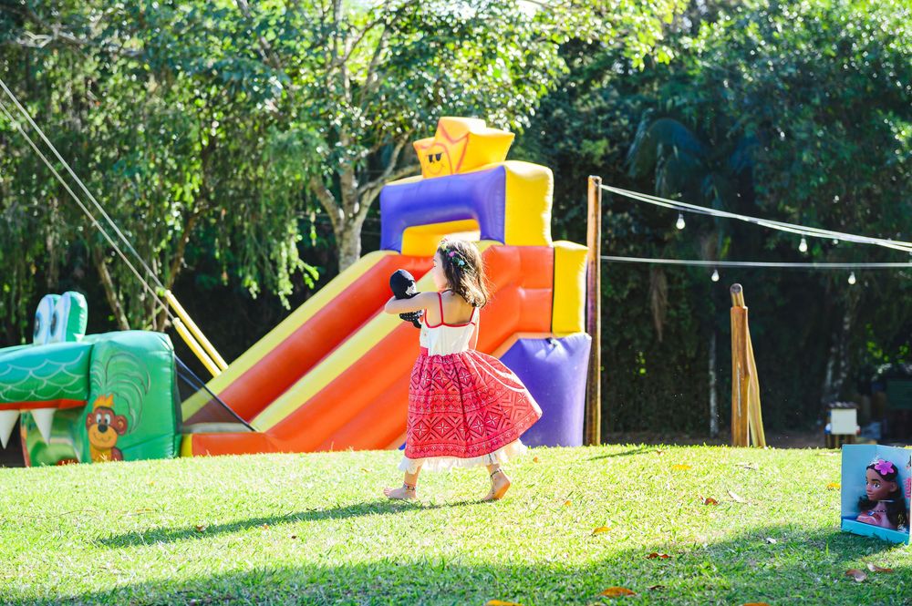 Colorful inflatable bounce houses and slides set up on a grassy lawn for outdoor children's entertainment.
