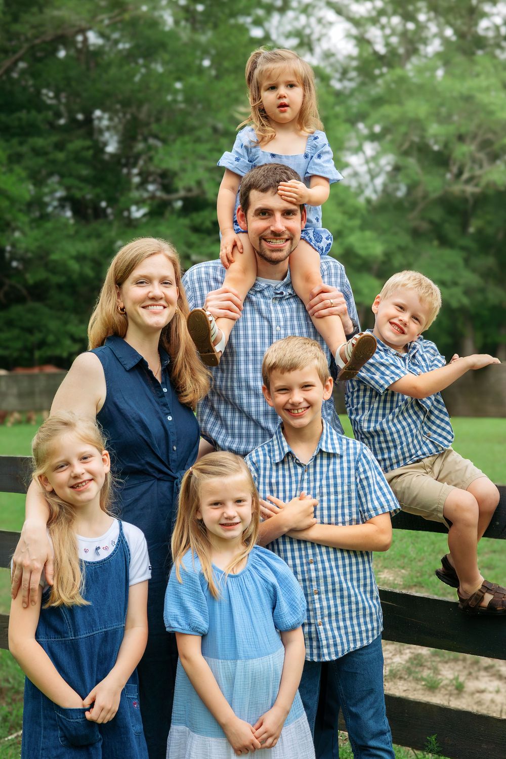 Family of 7 smile by a fence during a family session in Athens, GA