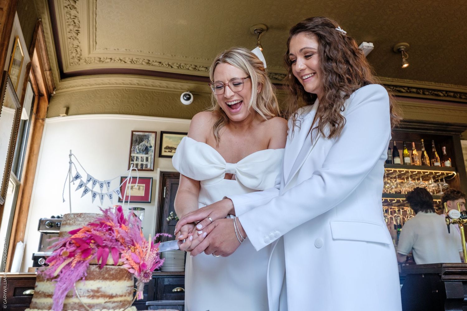 Stylists collaborate while working with bridal party members to create elegant wedding day hairstyles in a salon setting.