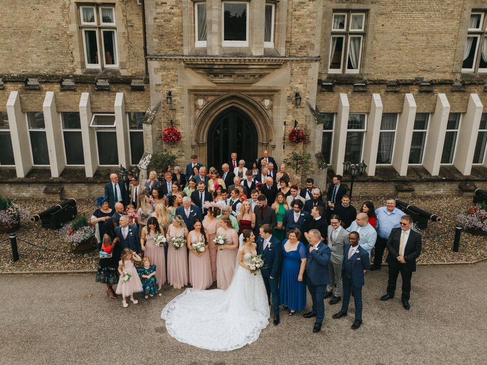 Wedding party gathered on steps of historic stone castle during outdoor celebration at Cave Castle - taken by Grimsby photographer.