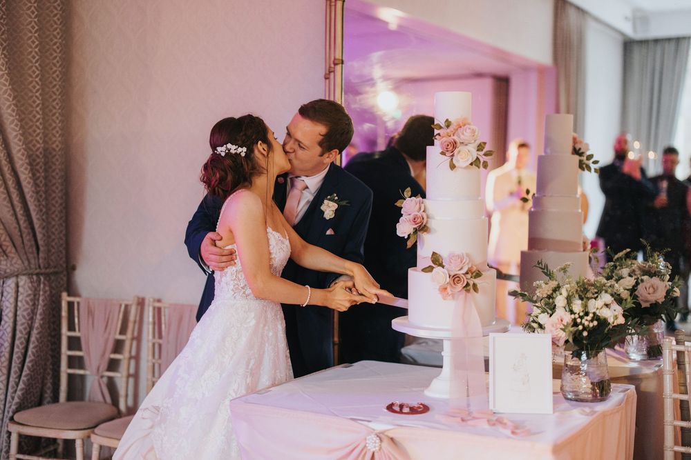 A couple shares an intimate kiss during their cake cutting at their wedding reception at Cave Castle - taken by Grimsby photographer.