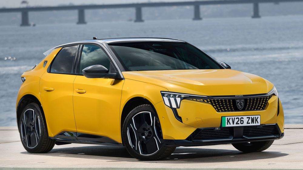 A bright yellow Peugeot 308 compact crossover SUV with black accents parked on an asphalt surface.