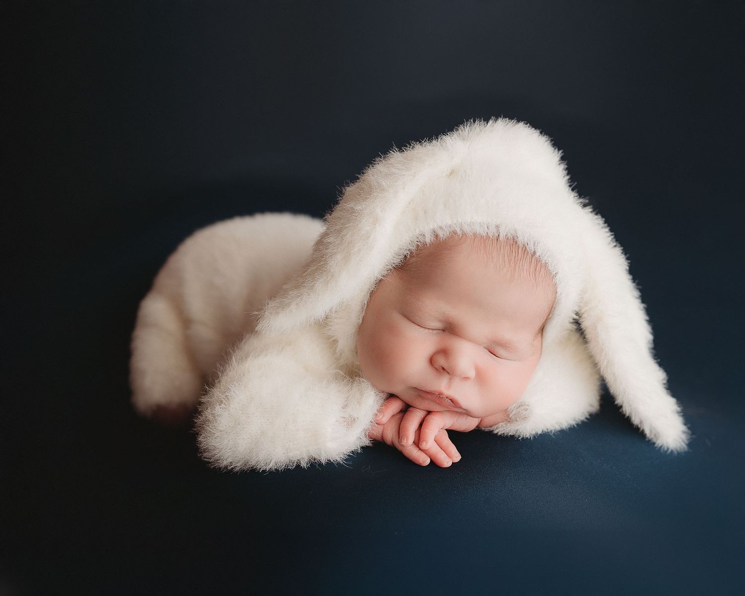 Professional photo of a newborn baby in a bunny outfit