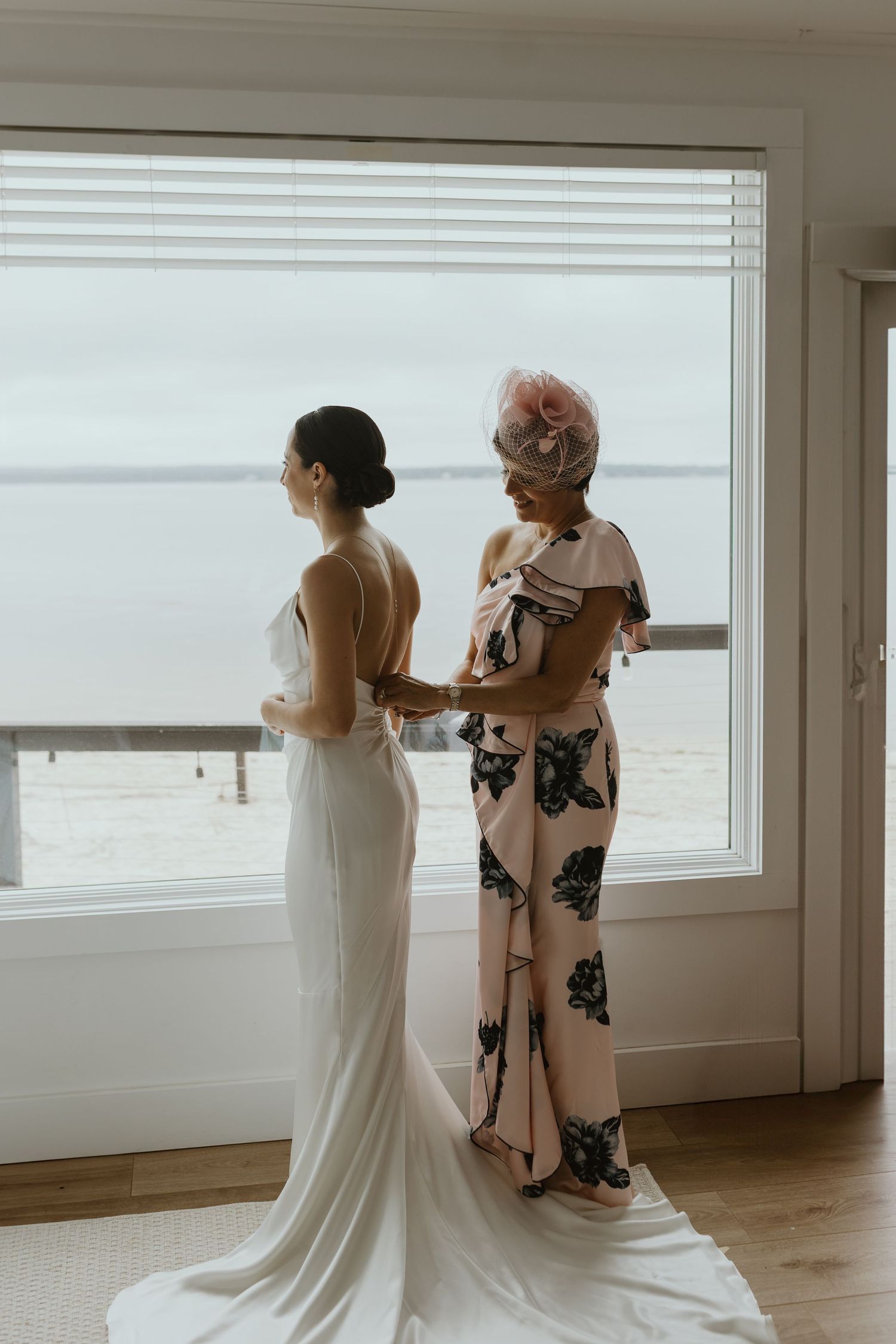 Mom buttoning Long Island brides wedding dress