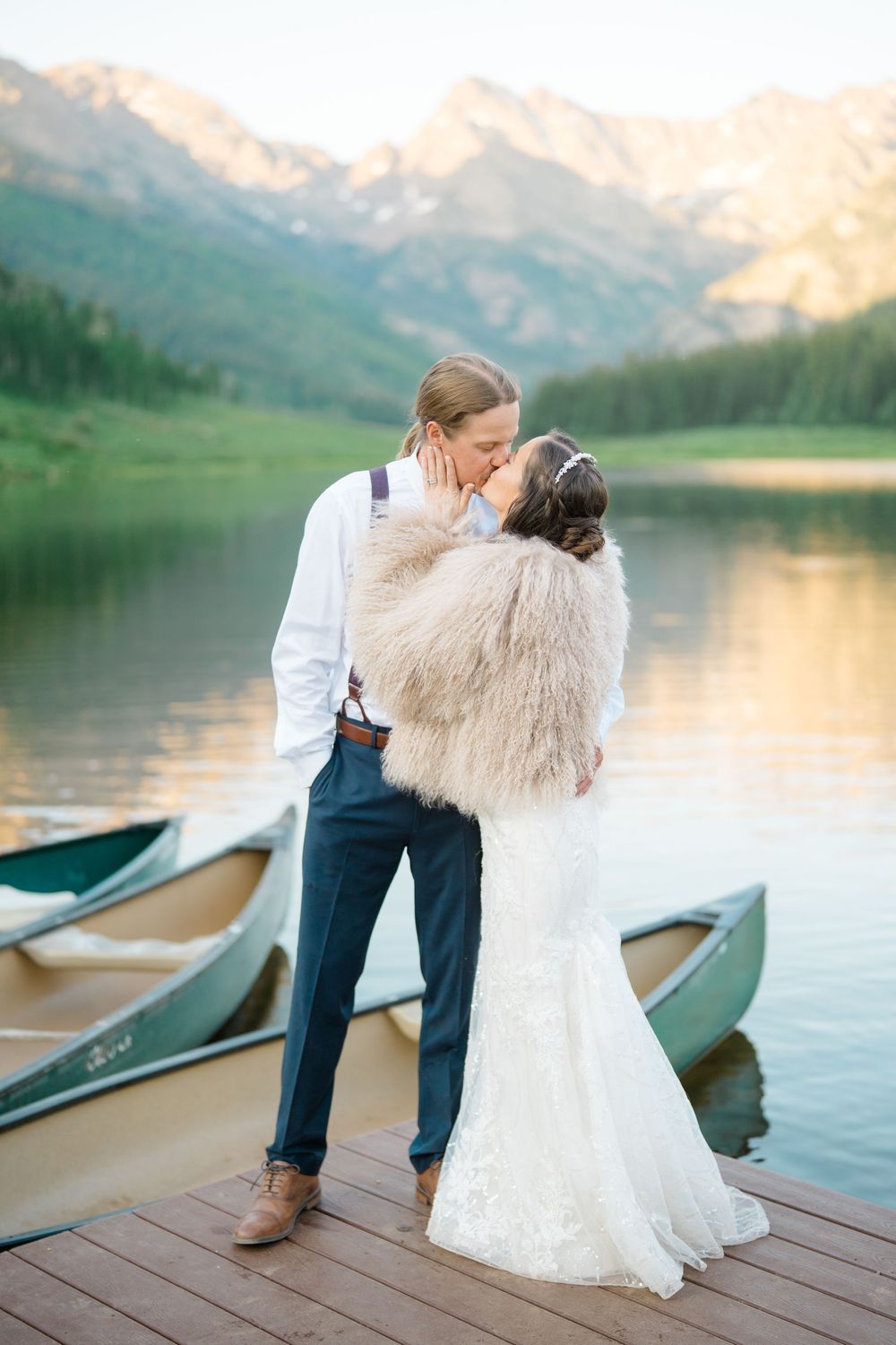 matt and danielle kiss at piney river ranch in front of lake and mountains
