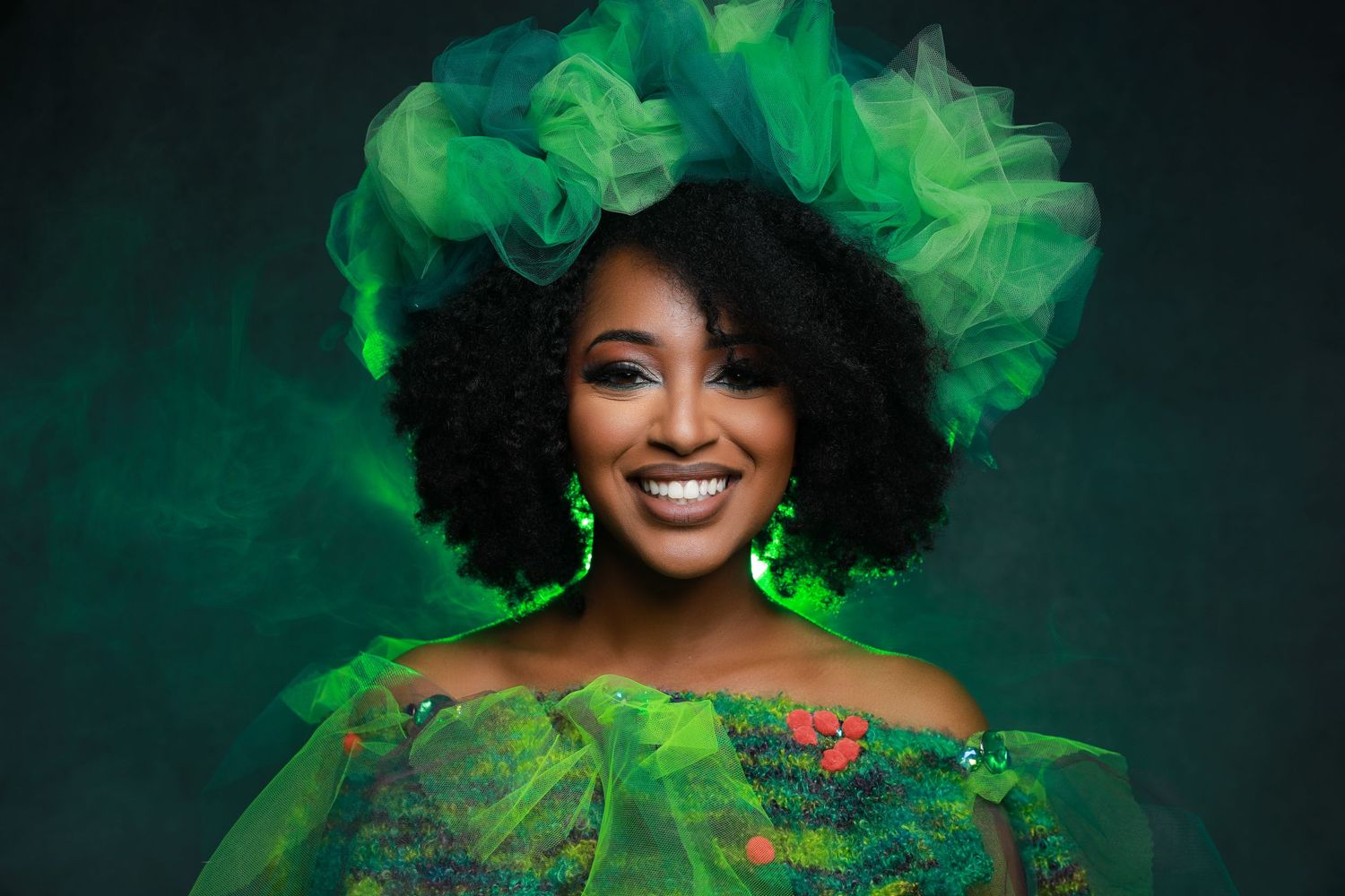 Festive portrait with green floral accessories and dramatic lighting.