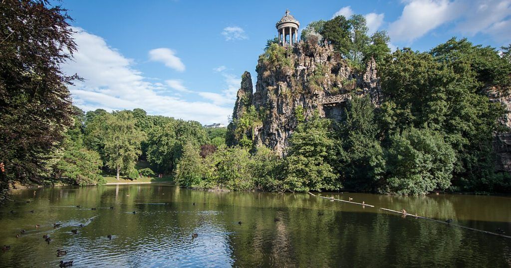 Pedra e lago do parque Buttes Chaumont