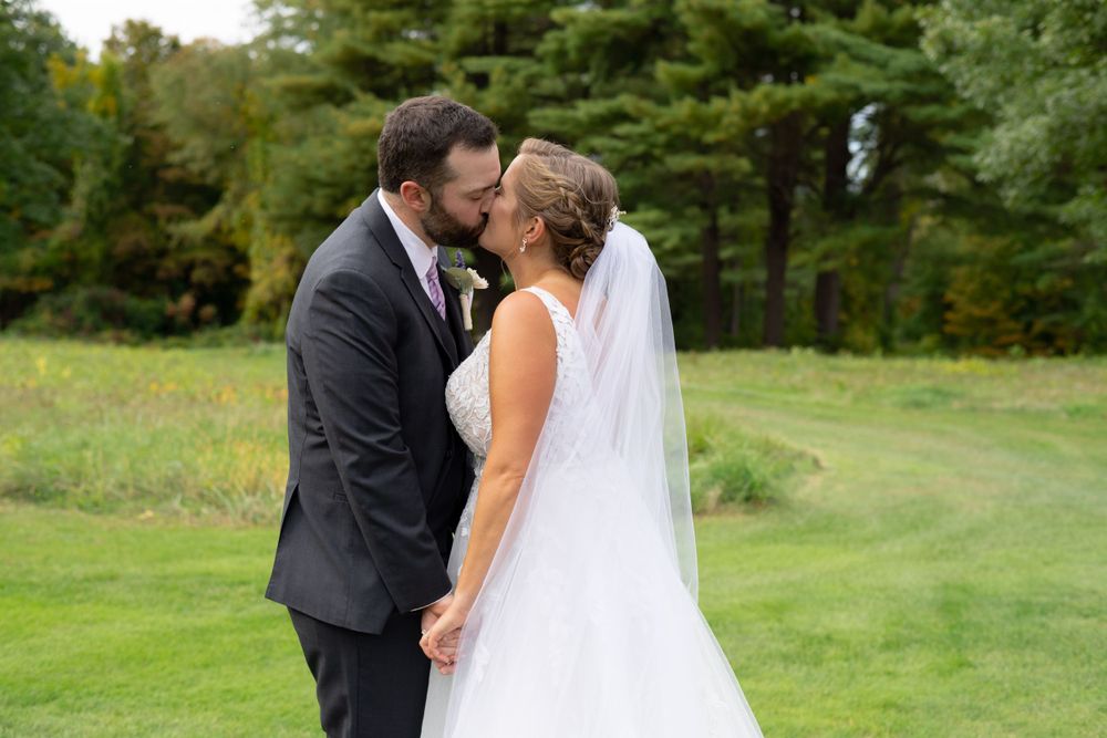 Tender moment between newlyweds on a scenic golf course with fall foliage.
