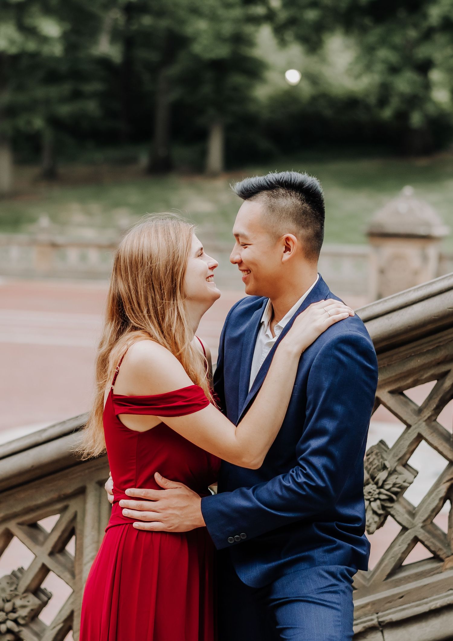 A romantic couple embraces while wearing formal attire in a garden setting.