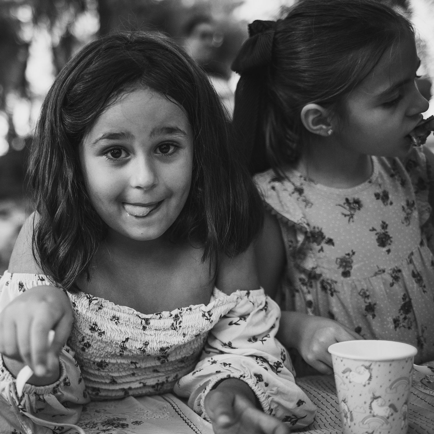 niña enseñando la lengua mientras espera su trozo de tarta del cumple. picnic en el parque