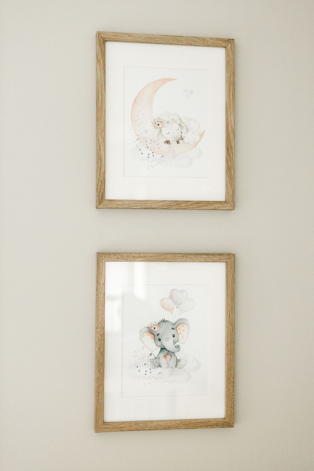 Two whimsical nursery art prints featuring a moon and elephant in soft pastel colors.