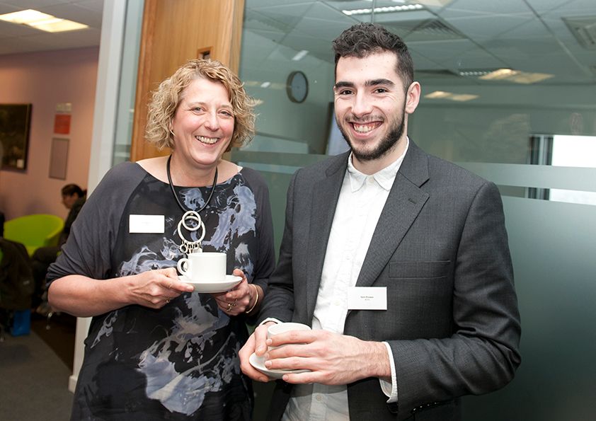 Two attendees pose with awards at a business networking event.