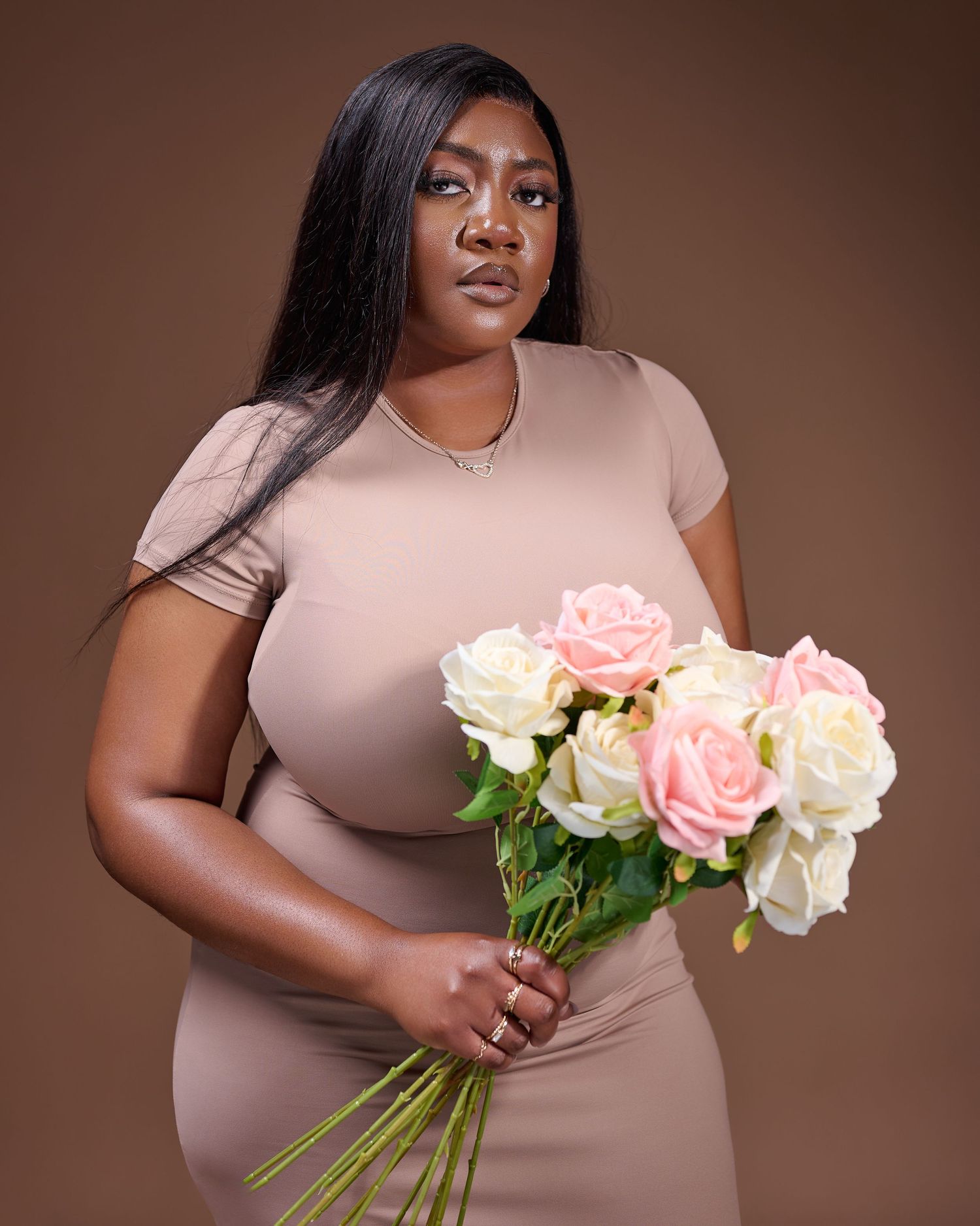 a lady wearing a cream dress holding flowers