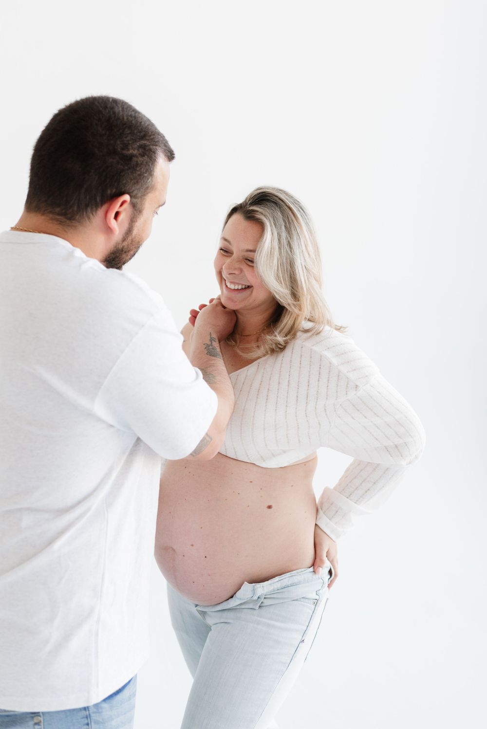 Couple wearing white at a timeless maternity shoot at Icon Studio Space by Toronto photographer Jess GC Photography
