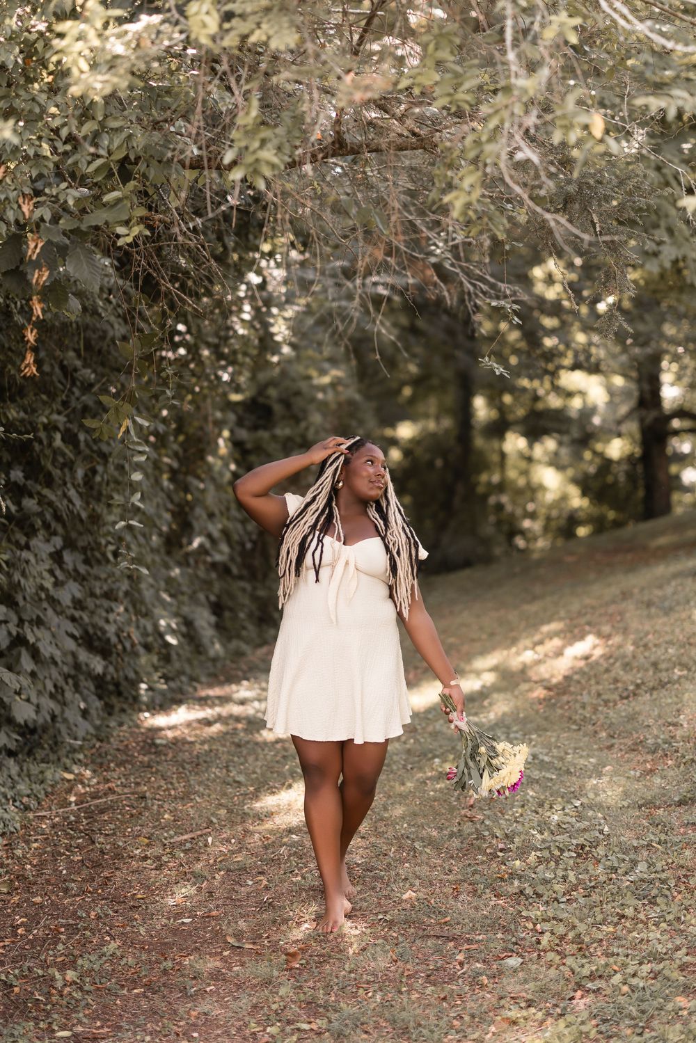A sequence of images shows a person in a white sundress dancing and twirling in a sun-dappled wooded outdoor setting.