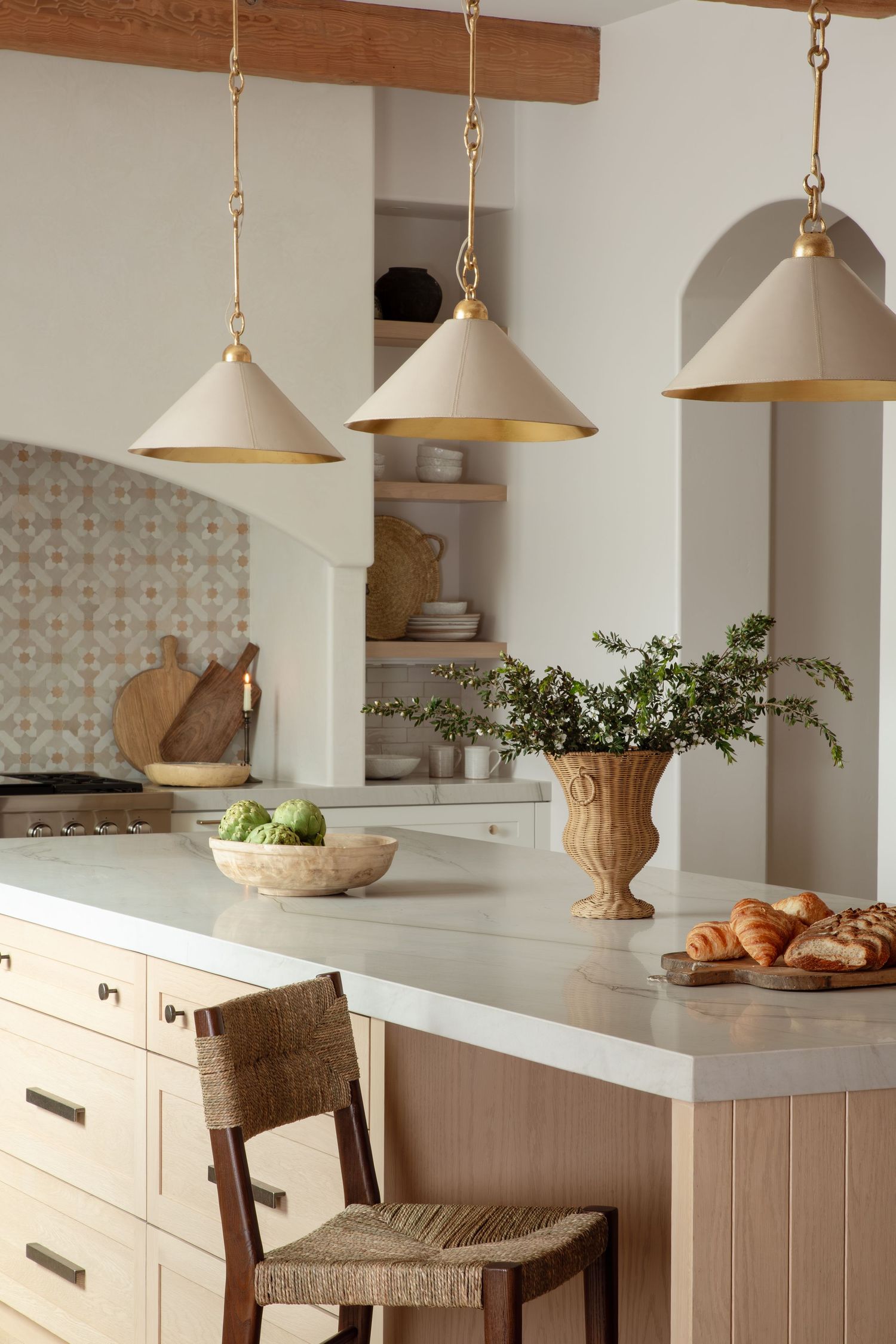 Modern bright kitchen featuring exposed wooden beams, light wood cabinetry, and a large center island with pendant lighting.