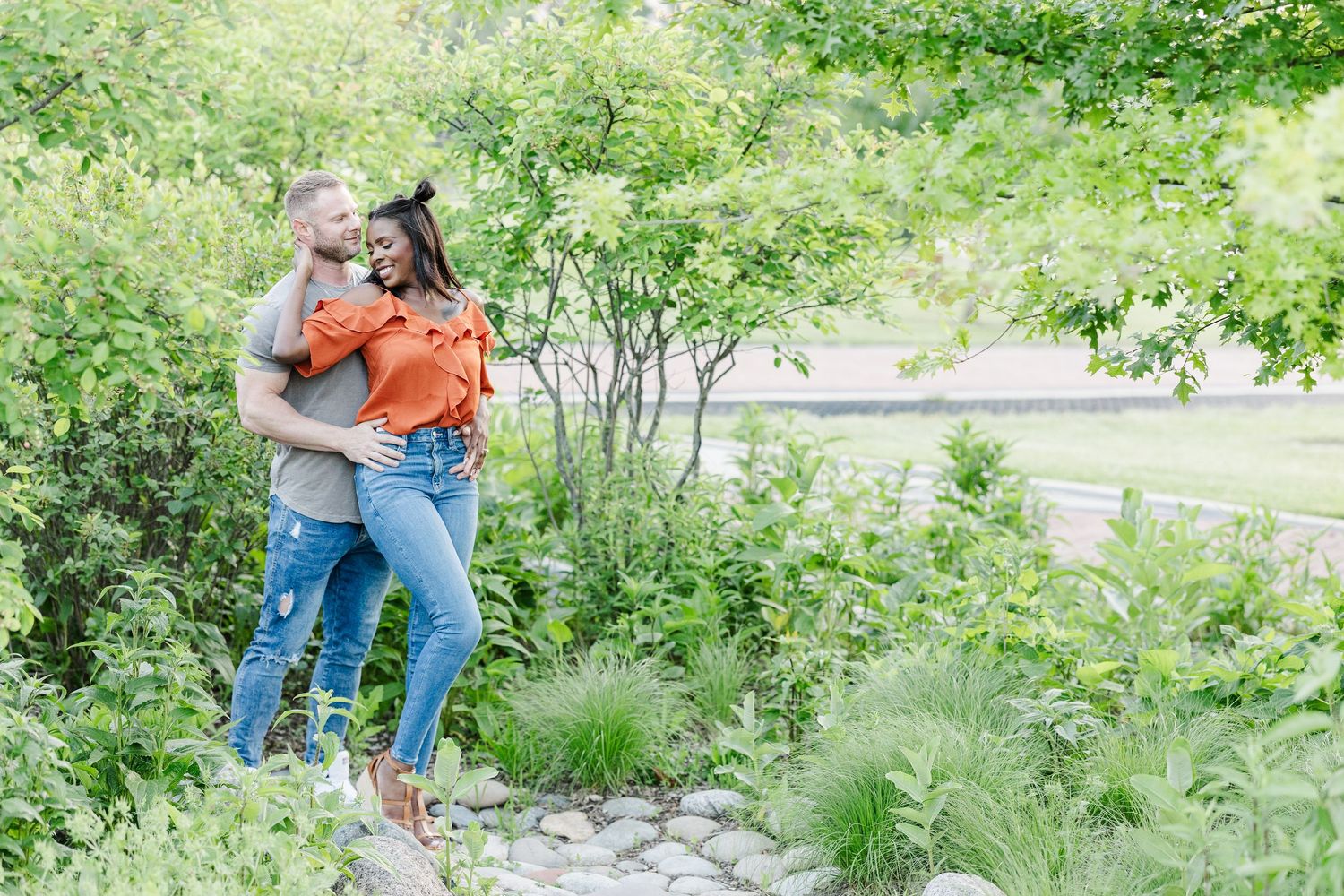 A couple walks together through a lush garden path on a sunny summer day.