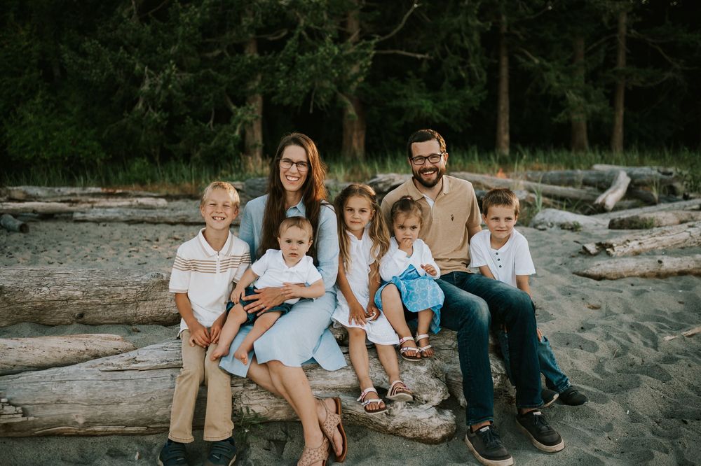 Comox Valley family photoshoot of mom and dad with five kids on driftwood Kye Bay Beach Portraits taken by photographer Soulfull Photographs