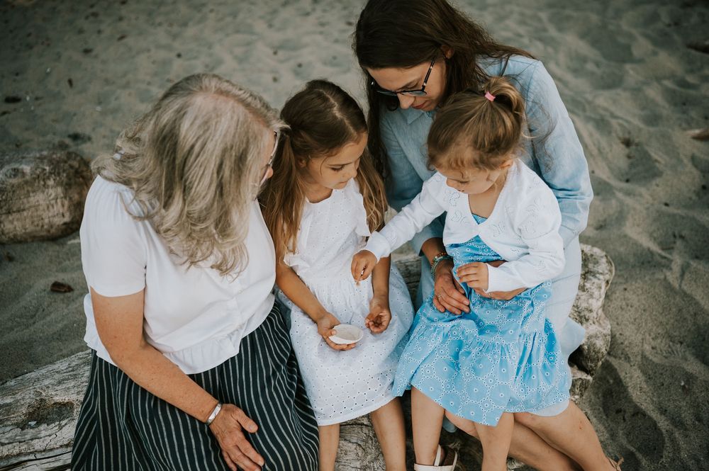 Comox Valley family photoshoot of girls snuggled up on log at Kye Bay Beach Portraits taken by photographer Soulfull Photographs