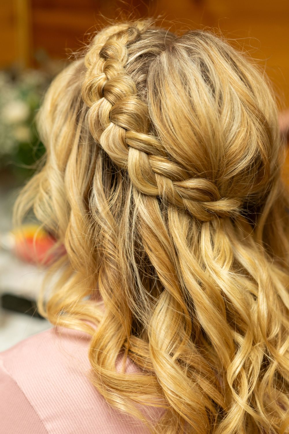 Close up of elegant blonde wedding hairstyle with braided details and soft curls.