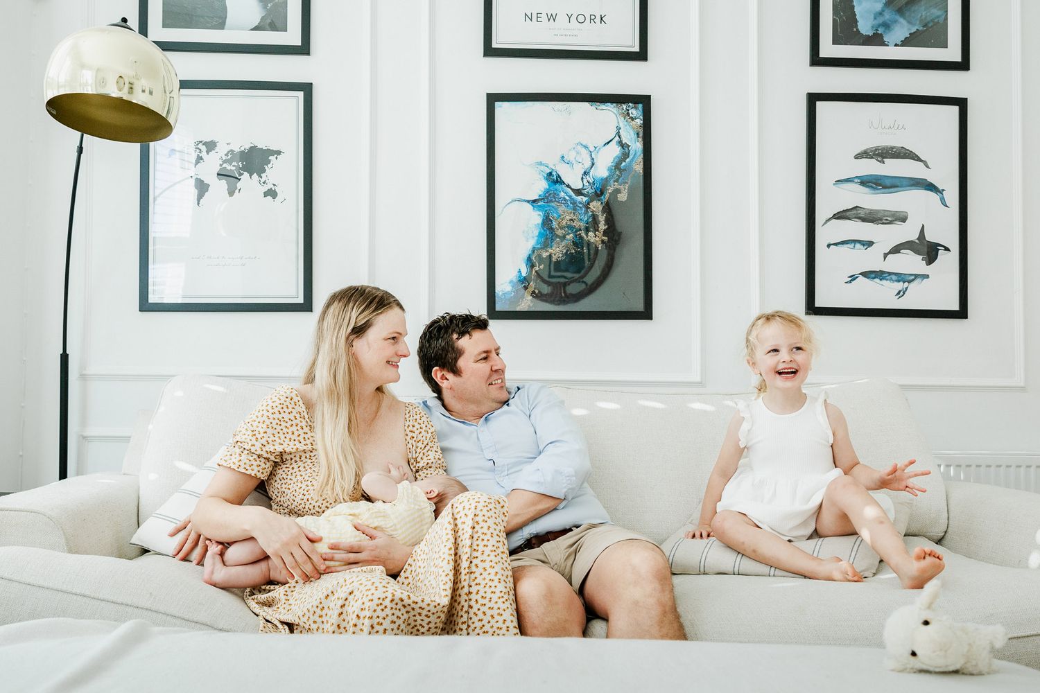 A young child bounces on the sofa at home during a natural in-home family photoshoot. Bristol family photography