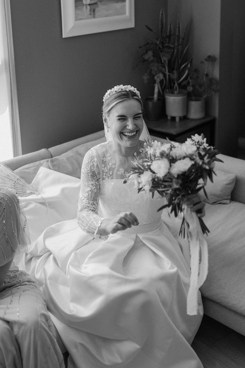 A smiling bride in a white wedding dress waits to leave for her London church wedding ceremony.